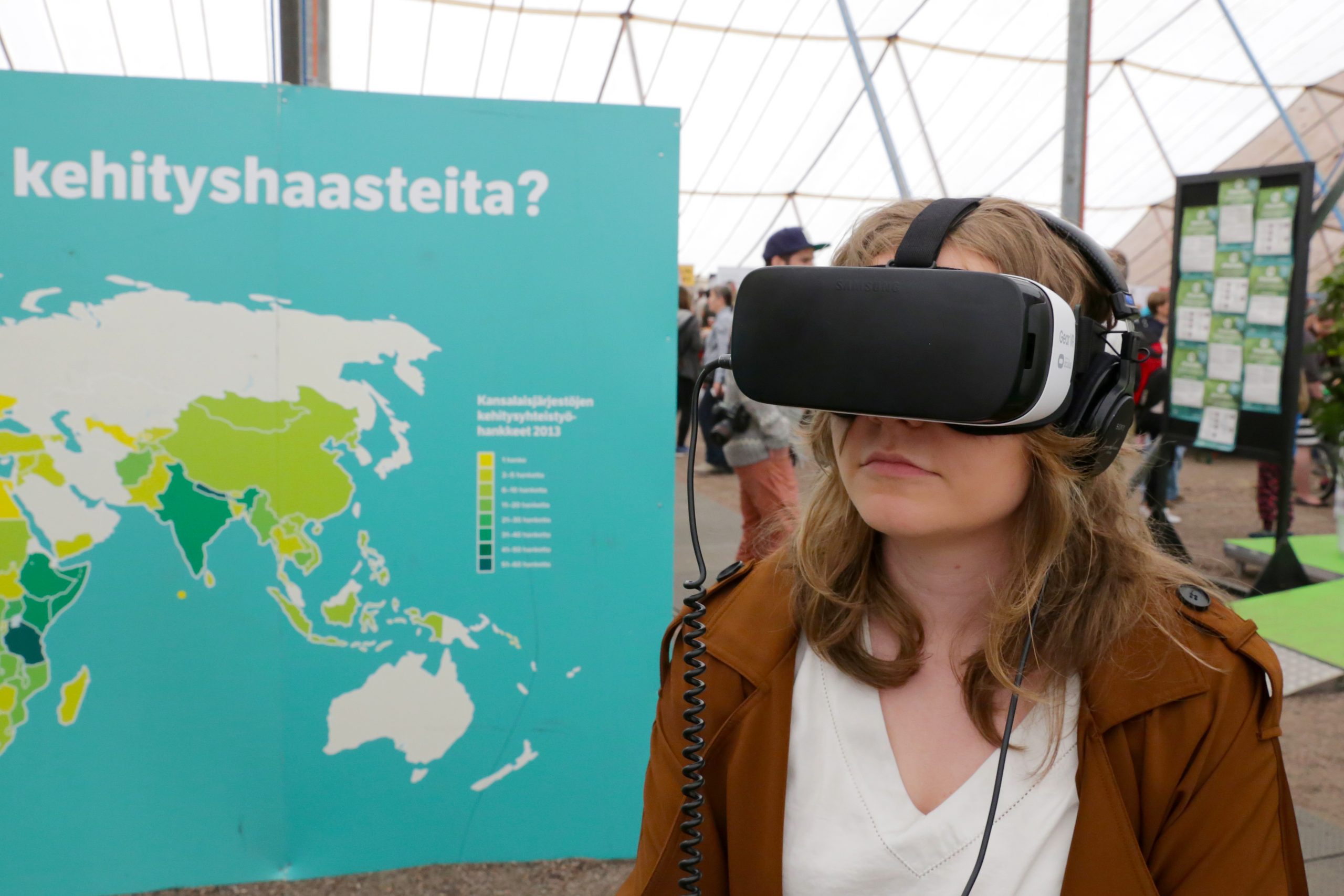 Nuori nainen Maailma Kylässä -festivaalilla VR-lasit päässä