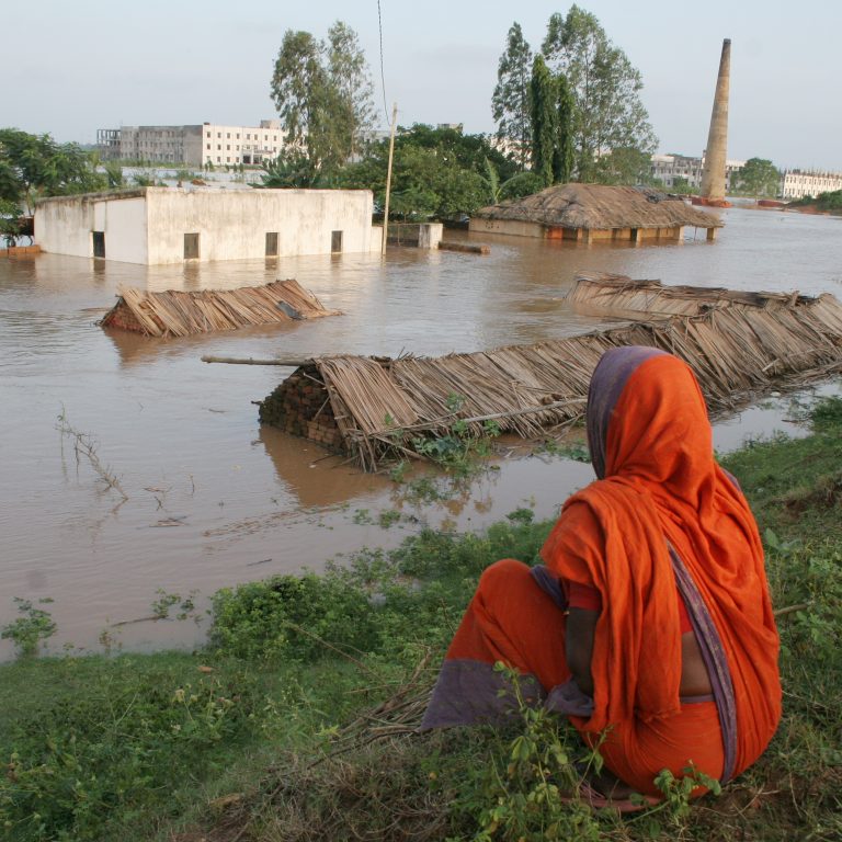Intian Odishan osavaltiossa asuva nainen katselee tulvaveden armoille jäänyttä kotiaan.