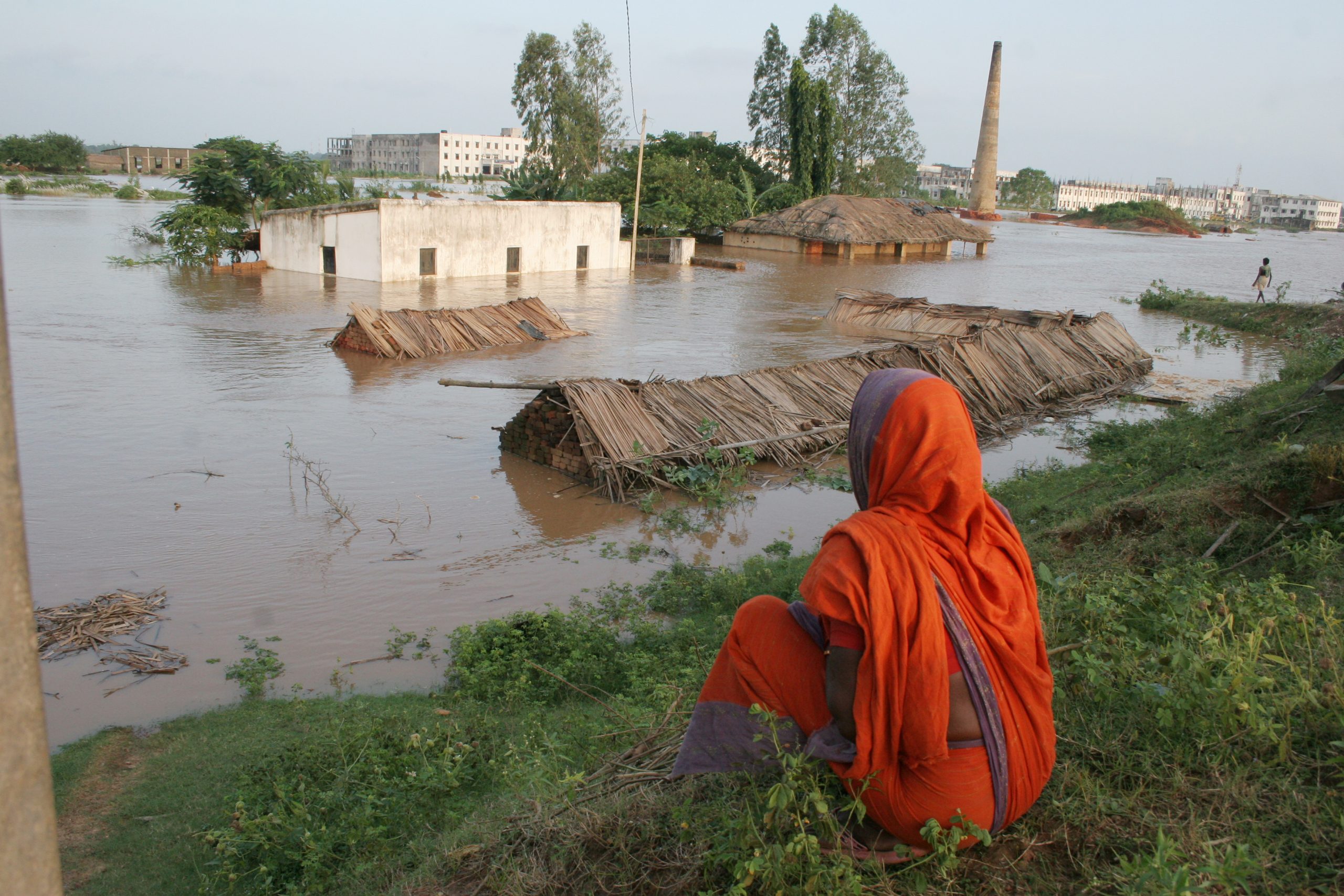 Intian Odishan osavaltiossa asuva nainen katselee tulvaveden armoille jäänyttä kotiaan.