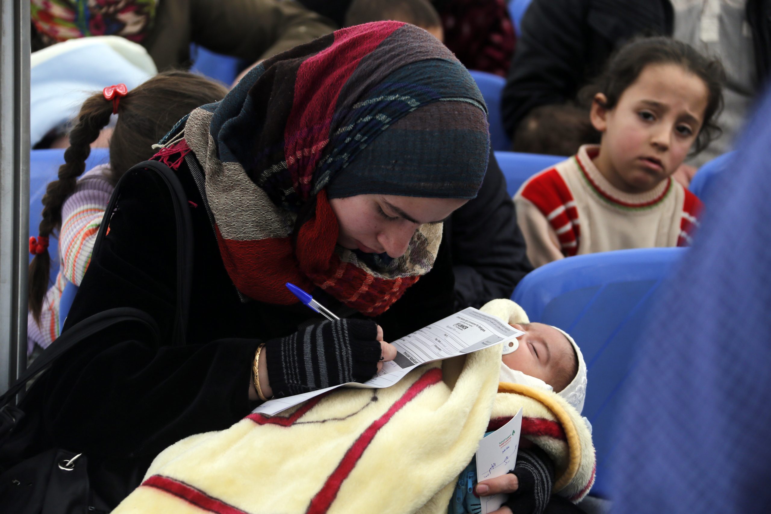 Nainen täyttää hakemusta UNHCR:n pakolaiskeskuksessa Libanonissa vuonna 2014.