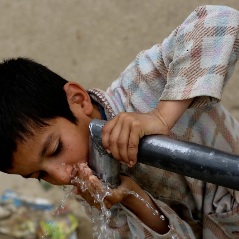 Afganistanilaispoika juo vettä Balkhin provinssissa vuonna 2015.