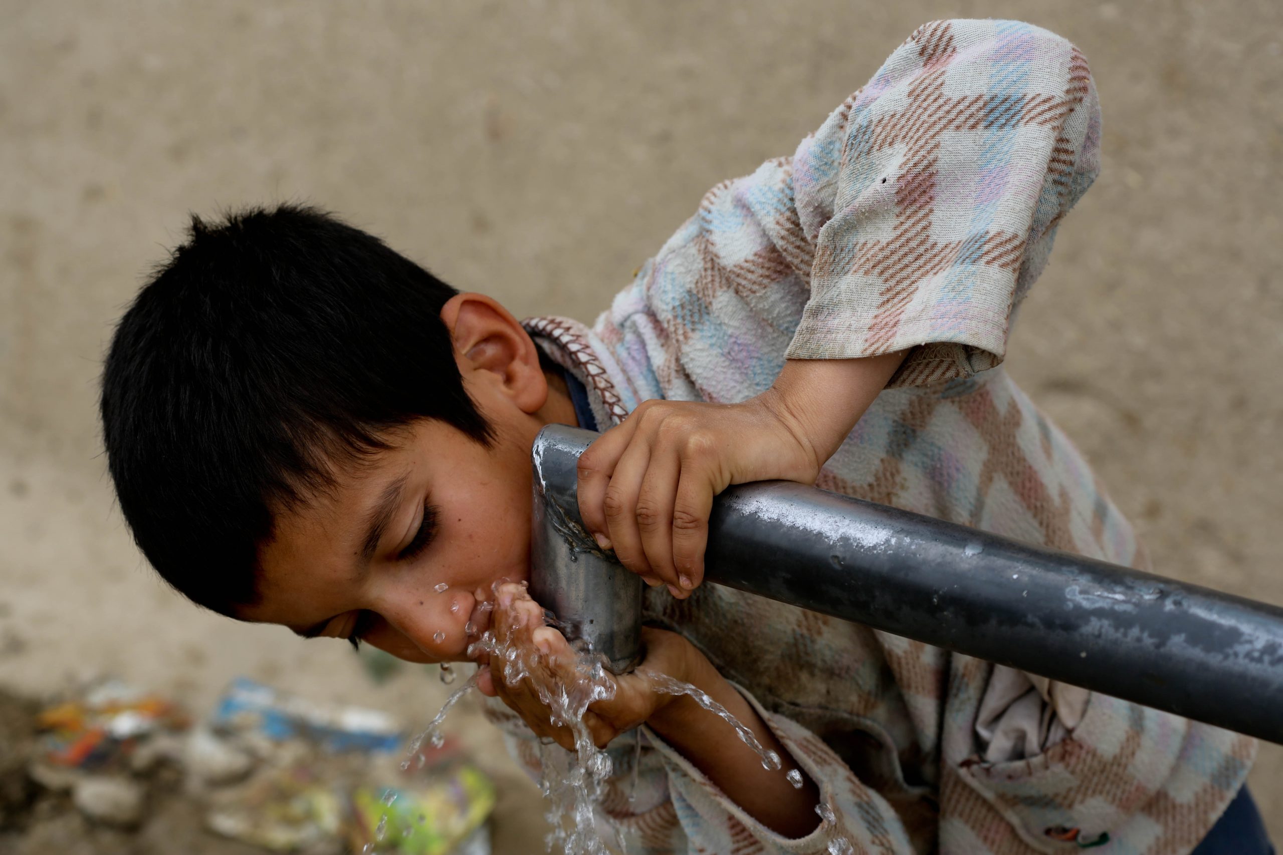 Afganistanilaispoika juo vettä Balkhin provinssissa vuonna 2015.