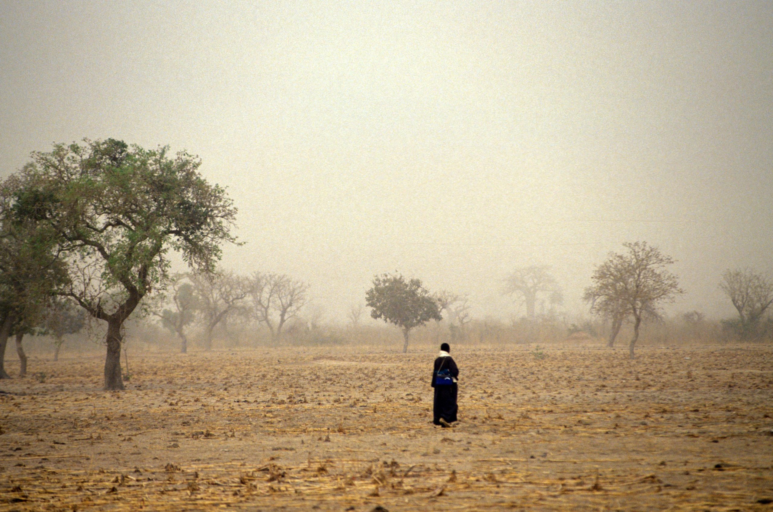 Nainen kävelee pellolla Malissa.