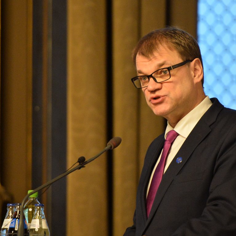 Kuvassa toimitusministeri Juha Sipilä puhuu mikrofoniin.
