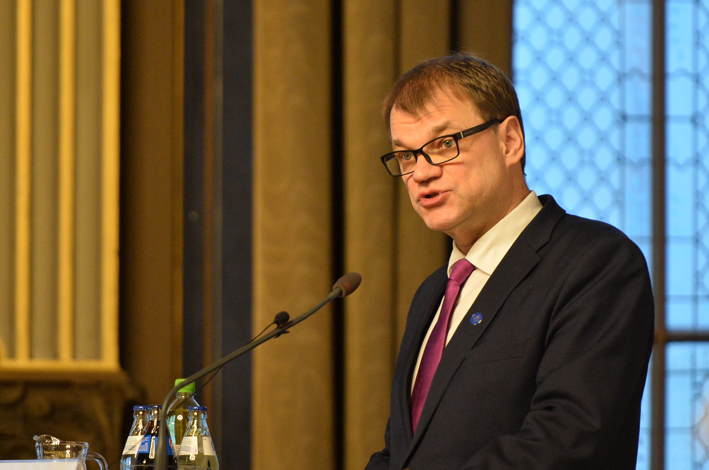 Kuvassa toimitusministeri Juha Sipilä puhuu mikrofoniin.