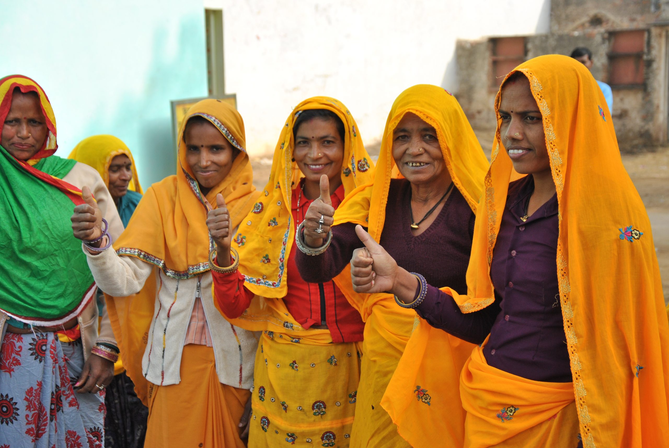 Intialaiset naiset näyttävät peukkua kameralle