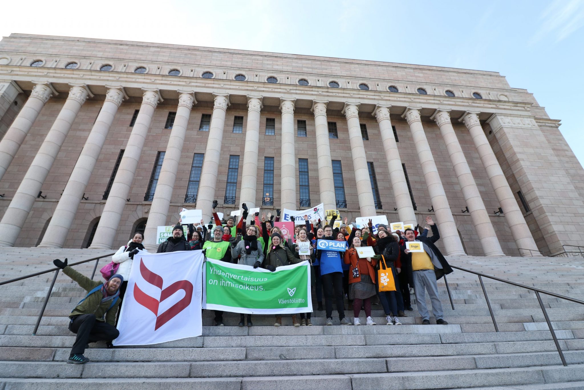 A group of NGO activists on the steps of the Finnish Parliament.