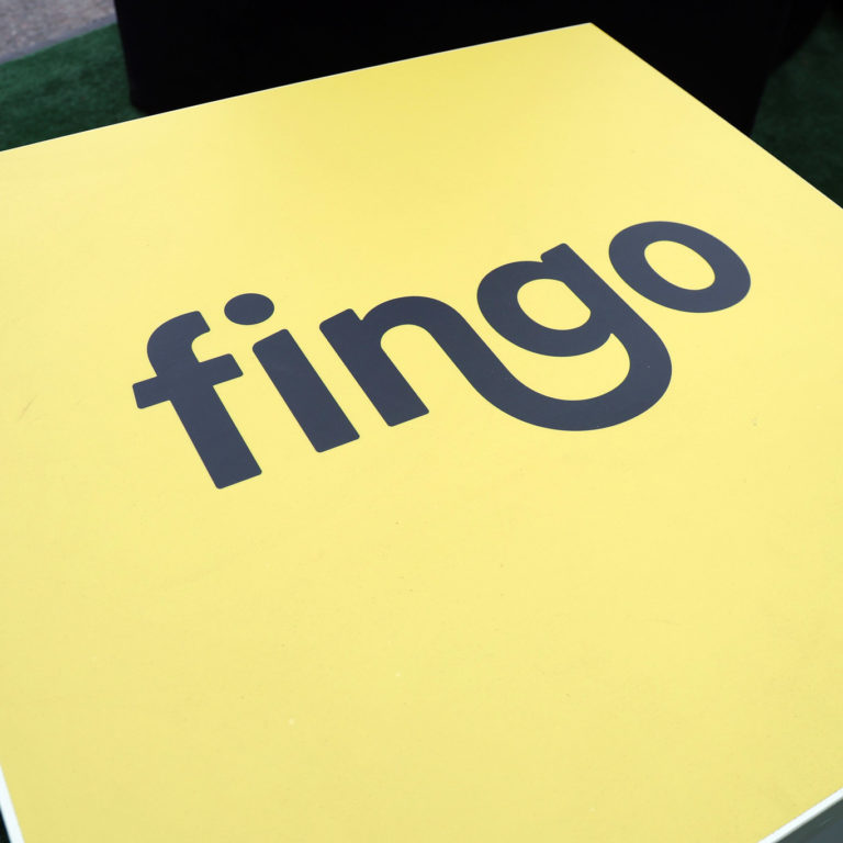 Keltainen pöytä, jossa musta Fingon logo.