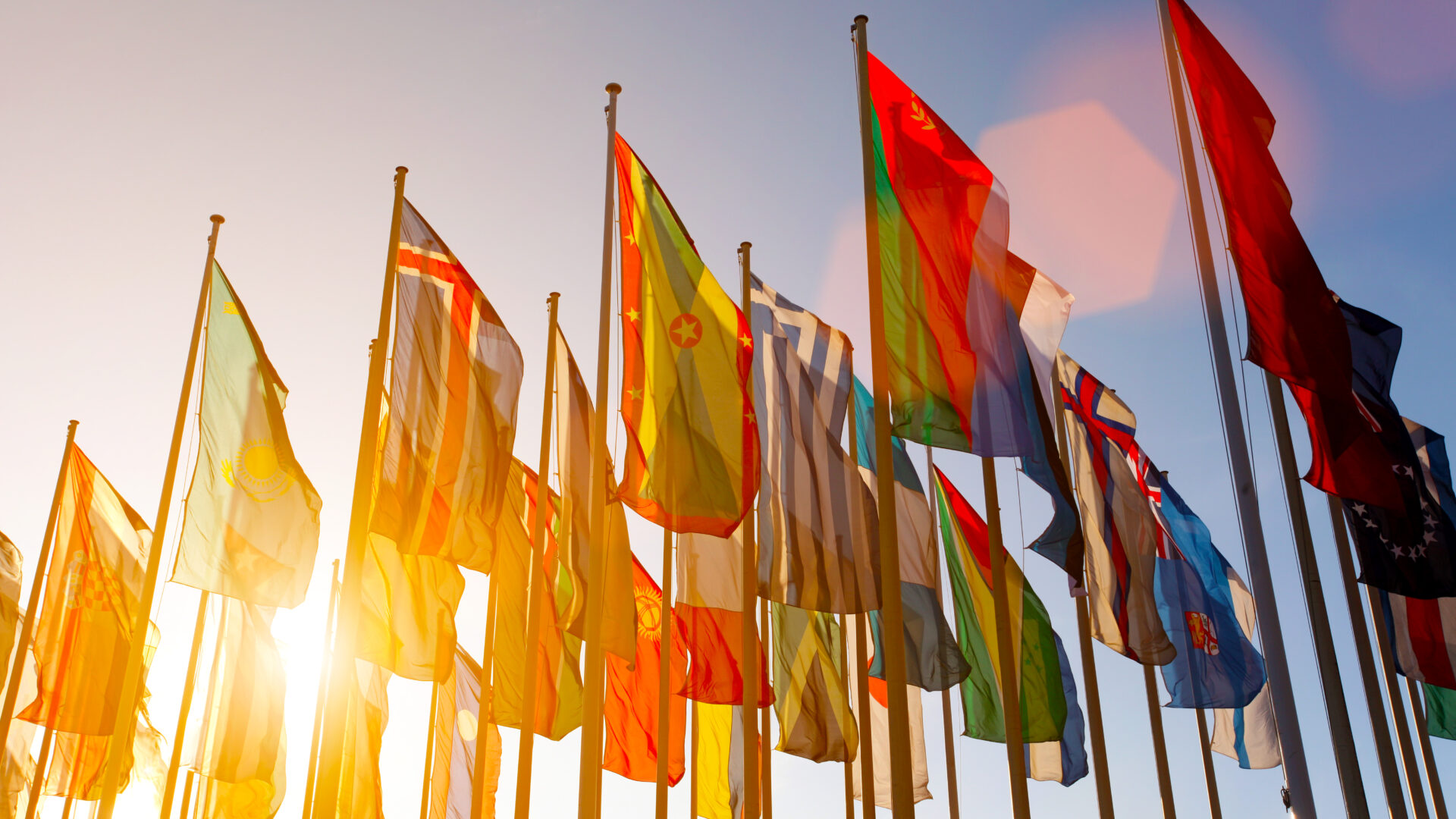 Kuva maailman maiden lipuista lippusaloissa auringonlaskussa.