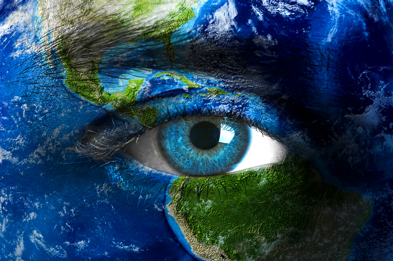 Ihmisen kasvojen ja silmän päälle maalattu maapallon kuvaa.