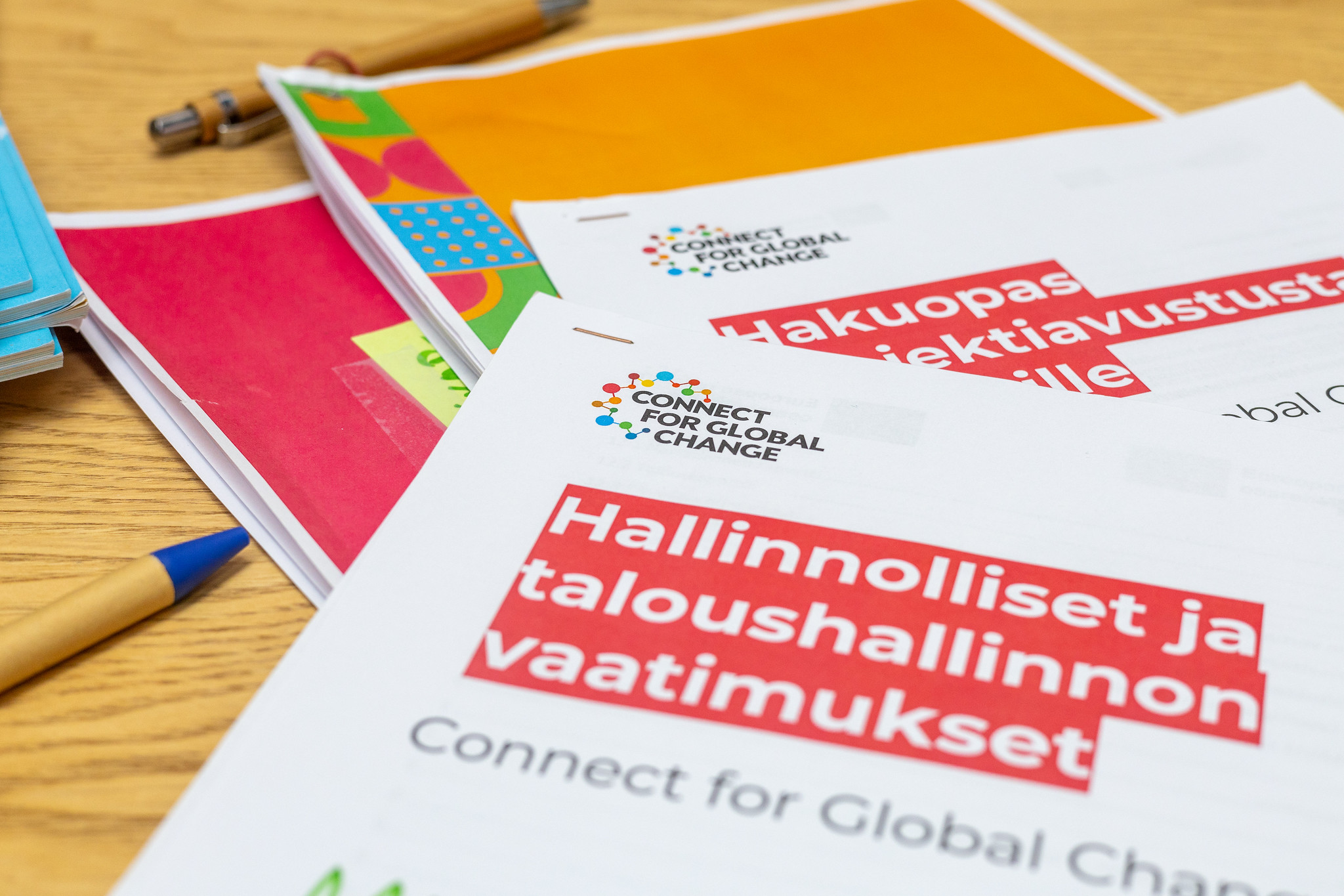 Connect for Global Change -hankkeen paperille printattuja julkaisuja pöydällä.