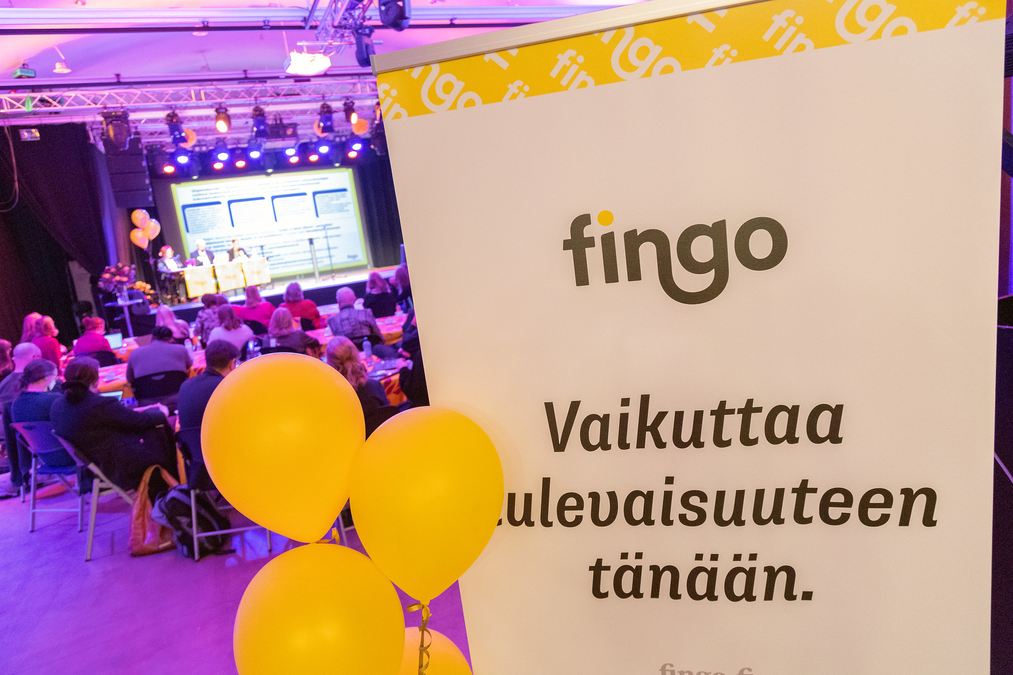 Fingon roll-up, jossa teksti Vaikuttaa tulevaisuuteen tänään ja keltaisia ilmapalloja.