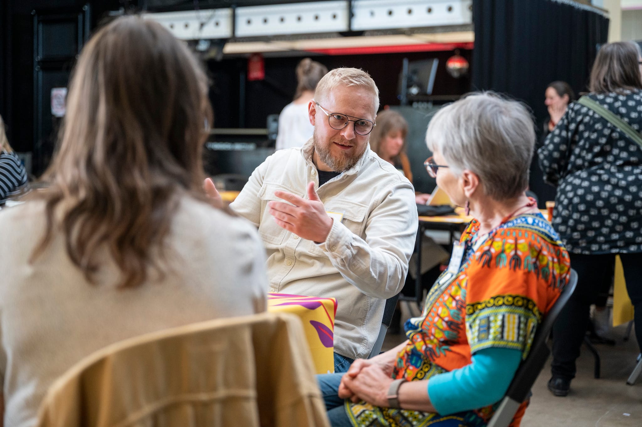 Kaksi henkilöä istuu pöydän ääressä ja keskustelee.