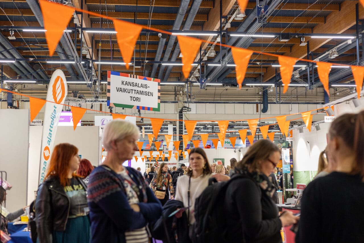 Kansalaisvaikuttamisen tori Educassa.|Fingon ständillä Educassa kaksi henkilöä esittelee ständin materiaaleja.
