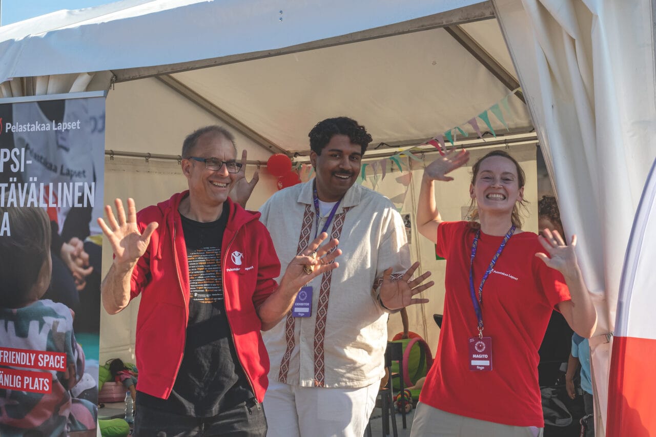 Exhibitors posing for the camera in front of a tent.