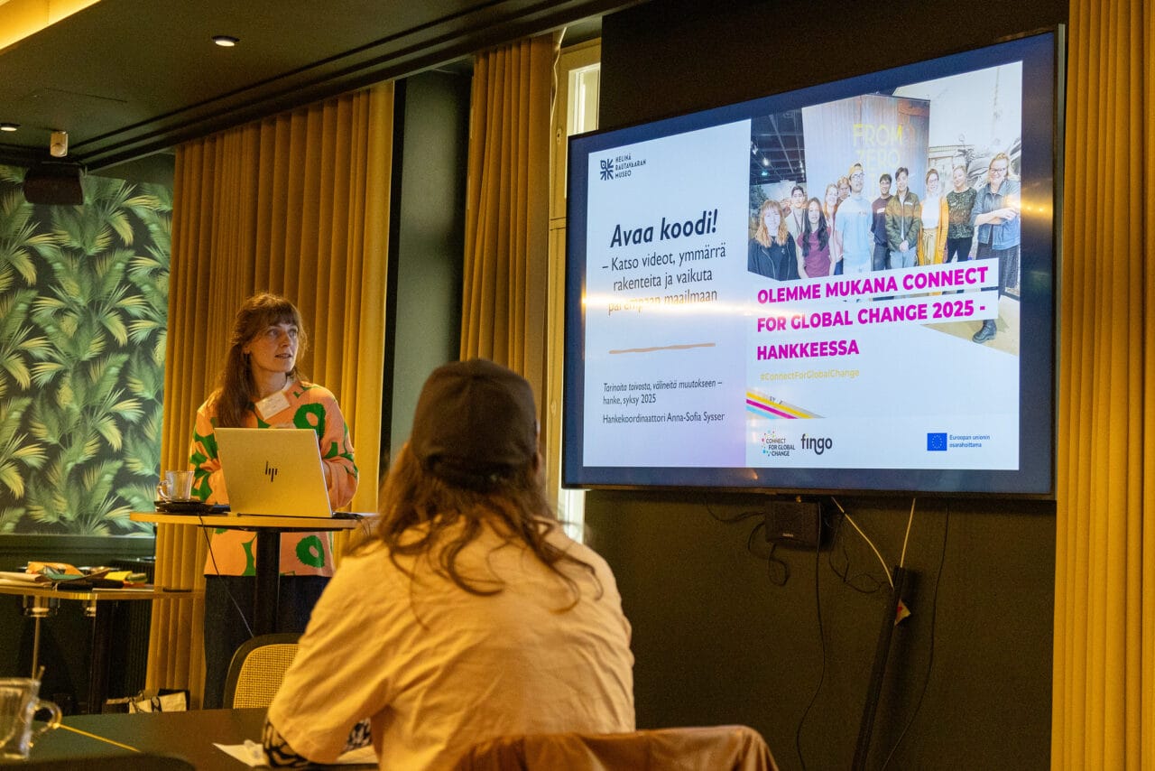 Henkilö näyttää power point -esitystä.