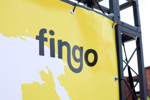 Fingon logo, jossa pala maailmankarttaa taustalla. Kangas kiinnitettynä trussitelineisiin.