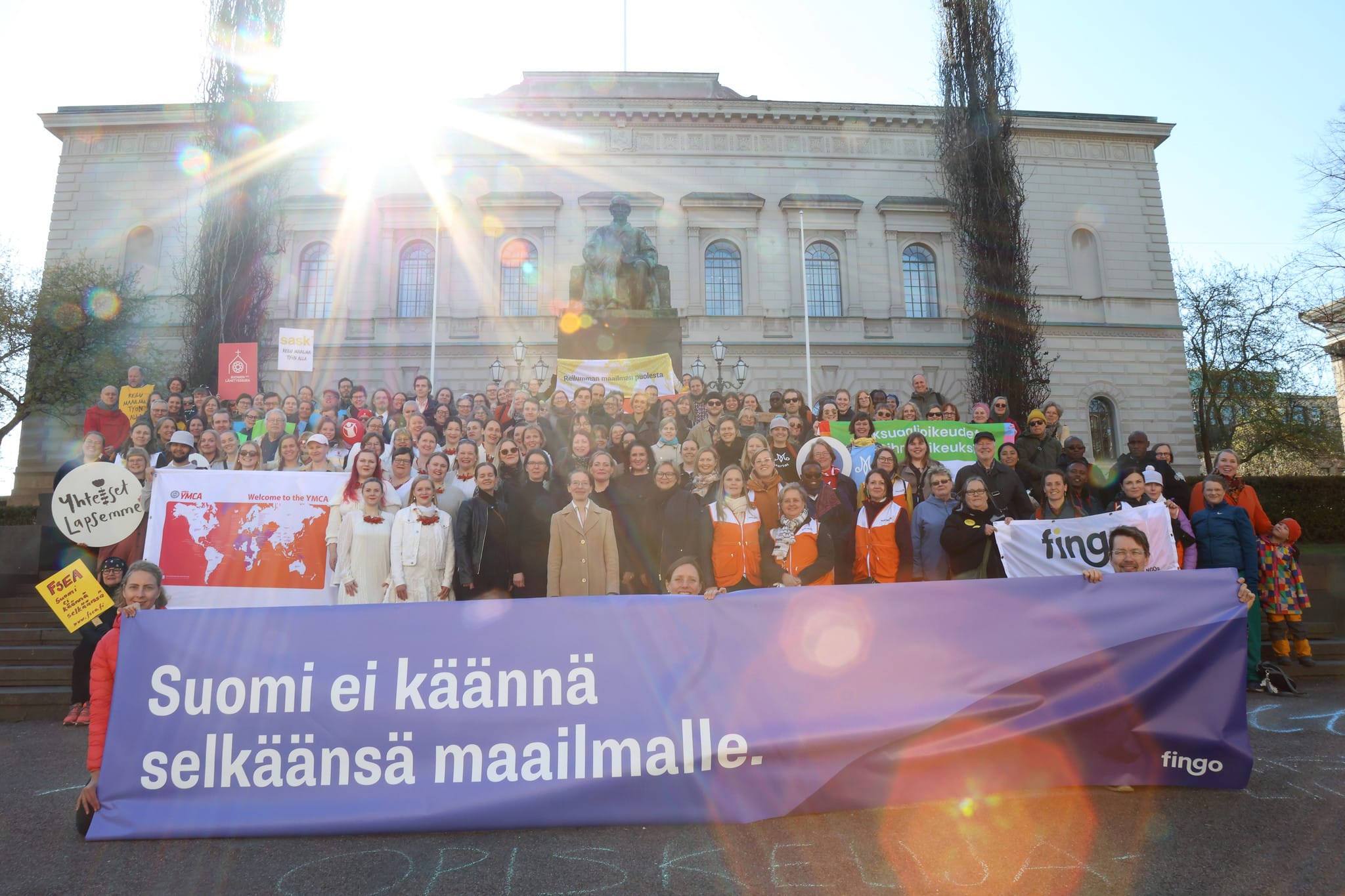 A big group of people posing with campaign banners.