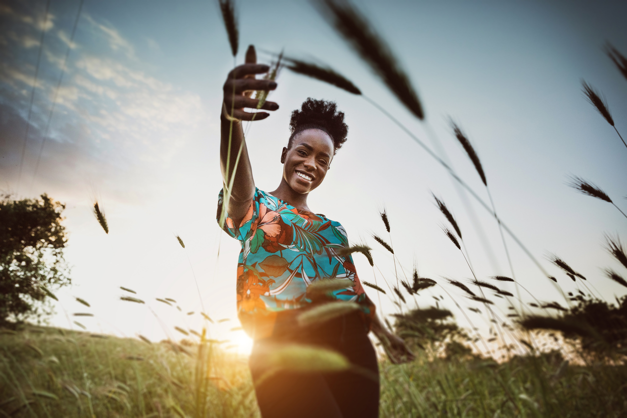Afro American woman with open arms breathing in the nature