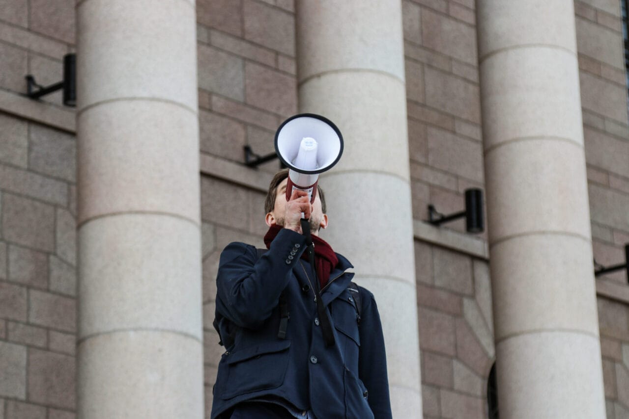 Mies huutaa megafoniin.