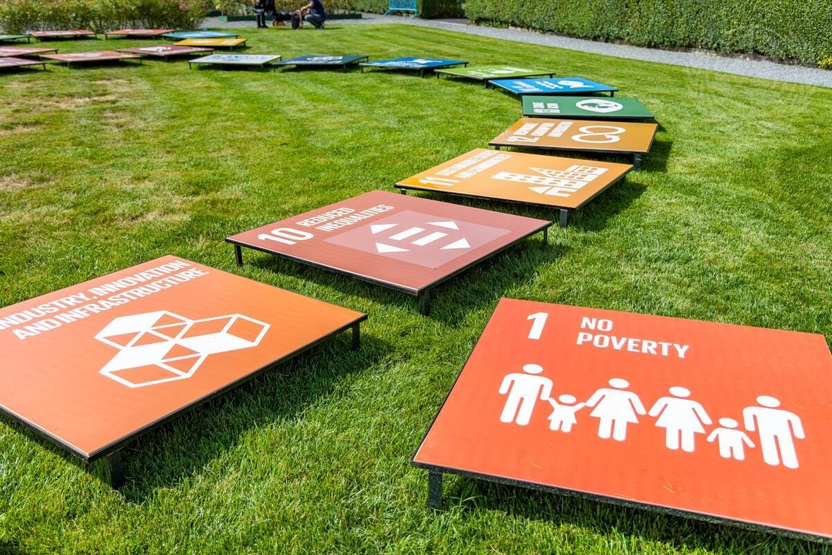 Näkymä kestävän kehityksen tavoitteiden kylteistä YK päämajan nurmikolla vuonna 2023.|